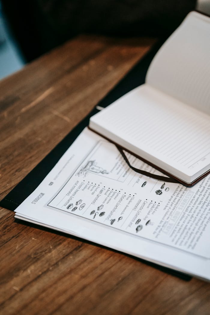 about-us An open notebook and printed document on a wooden table, ideal for business or education themes.