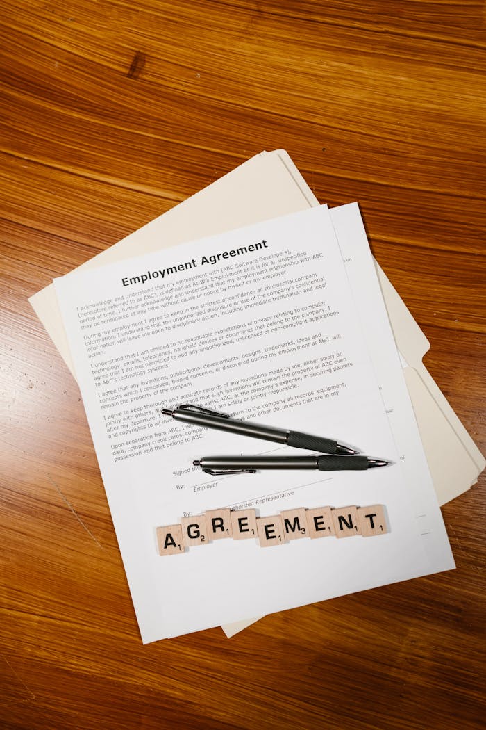 services-03 Employment agreement with Scrabble tiles spelling 'AGREEMENT' on wooden surface, captured in detail.